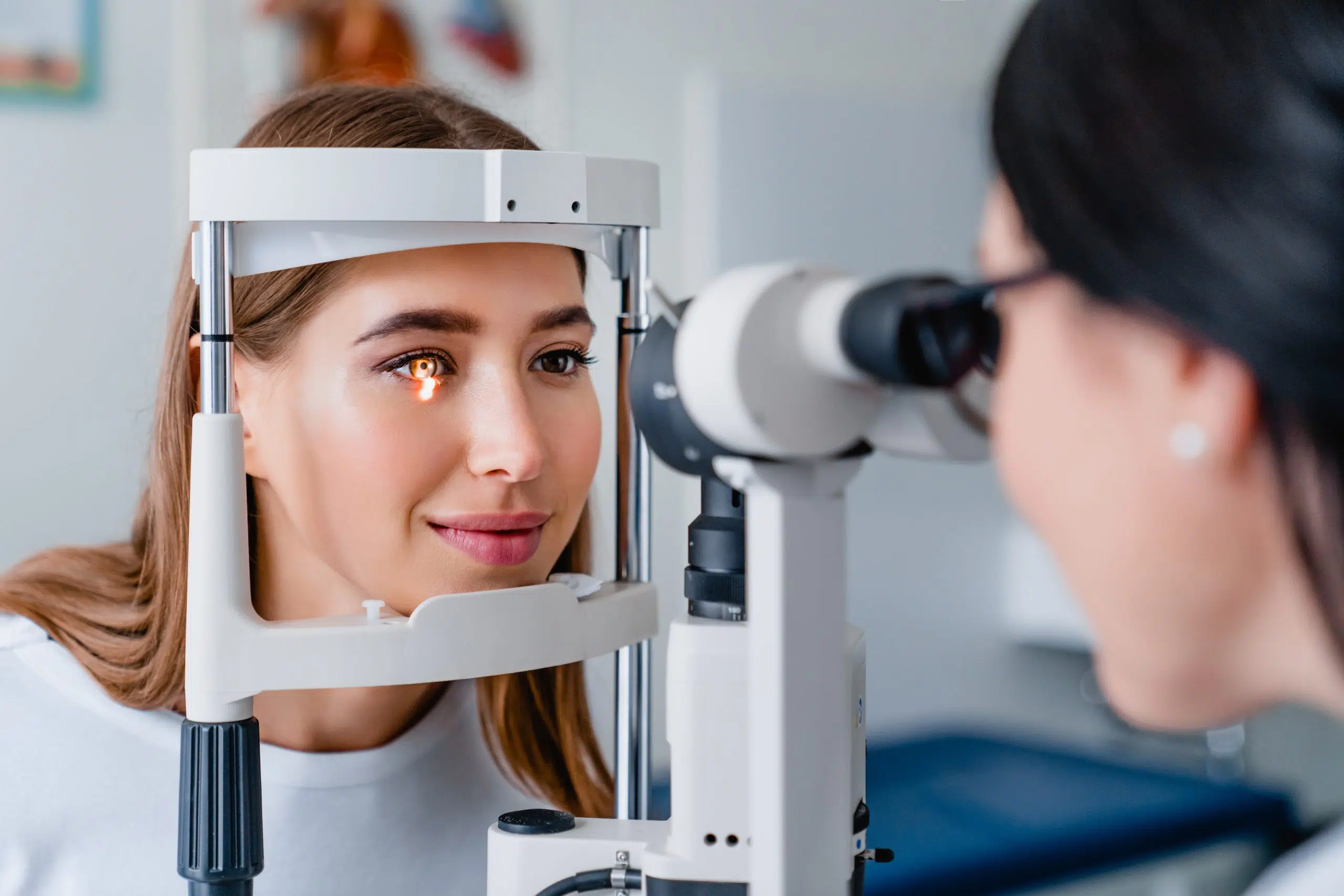 Patient seated at a slit lamp while a clinician examines her eyes