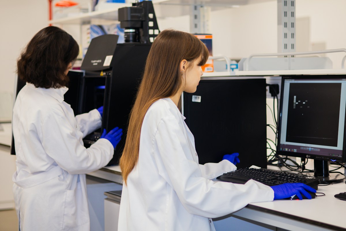 Clinical research team in the laboratory Two researchers in lab coats and gloves working at laboratory instruments